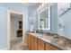 Stylish bathroom vanity with granite countertop and a brightly lit mirror, adjacent to a room with comfortable seating at 116 Hibiscus Dr, Clayton, NC 27527