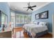 Bright bedroom features a bay window, hardwood floors, ceiling fan and blue walls at 116 Hibiscus Dr, Clayton, NC 27527