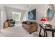 Upstairs bonus room with sofa and desk, featuring a large decorative painting at 116 Hibiscus Dr, Clayton, NC 27527