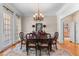 Formal dining room with elegant chandelier, large window, and hardwood flooring at 116 Hibiscus Dr, Clayton, NC 27527