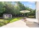 Green backyard featuring a storage shed, patio with dining set and umbrella, and a well-maintained lawn at 1230 Sunday Silence Dr, Knightdale, NC 27545