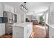 Bright kitchen features white cabinets, stainless steel appliances, and center island, open to the living area at 1230 Sunday Silence Dr, Knightdale, NC 27545