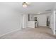 Open-concept living room with neutral walls and carpet flooring, leading to other parts of the house at 1230 Sunday Silence Dr, Knightdale, NC 27545