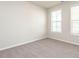 Bedroom with neutral carpet, two windows with blinds, and natural light at 1242 Underbrush Dr, Durham, NC 27703