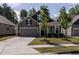 Charming home featuring a two-car garage, well-maintained lawn, and beautiful curb appeal at 1242 Underbrush Dr, Durham, NC 27703
