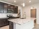 Stylish kitchen featuring granite counters, dark cabinets, stainless steel appliances, and light wood floors at 1242 Underbrush Dr, Durham, NC 27703