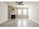 Spacious living area with a stone fireplace, ceiling fan, and hardwood floors at 1242 Underbrush Dr, Durham, NC 27703