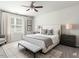 The main bedroom has a large bed, and a seating area with large windows and neutral-toned walls at 1242 Underbrush Dr, Durham, NC 27703