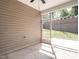 Back porch featuring screened windows, beige siding, and a view of the fenced backyard at 1242 Underbrush Dr, Durham, NC 27703