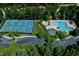 Aerial view of community pool, tennis courts and a parking lot surrounded by lush trees at 1276 Dalgarven Dr, Apex, NC 27502