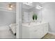 Bright bathroom features a double sink vanity with white cabinets and neutral countertops and a glimpse of the connected bedroom at 1276 Dalgarven Dr, Apex, NC 27502