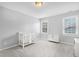 Cozy bedroom with neutral-toned walls and carpet, two windows, and a white crib with a coordinating dresser at 1276 Dalgarven Dr, Apex, NC 27502