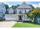 Charming two-story home with a well-manicured lawn, attached garage, and classic architectural details at 1276 Dalgarven Dr, Apex, NC 27502