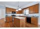 Well-equipped kitchen with wood cabinetry, granite countertops, stainless steel appliances and center island at 1276 Dalgarven Dr, Apex, NC 27502