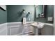Stylish powder room with decorative wainscoting, pedestal sink, and modern fixtures at 1276 Dalgarven Dr, Apex, NC 27502