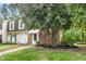View of the townhouse with a manicured lawn and a mature tree in the front yard at 13 Patriot Cir, Durham, NC 27704