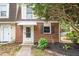 Close up of the front exterior showing brick facade, white door with awning, and mature landscaping at 13 Patriot Cir, Durham, NC 27704