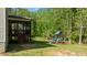 Backyard view with a screened porch, playset, and natural wooded surroundings at 130 Hilldebrant Dr, Franklinton, NC 27525
