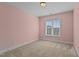 Cozy bedroom featuring pink walls, a neutral carpet and a window offering natural light at 130 Hilldebrant Dr, Franklinton, NC 27525