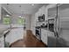 Modern kitchen features stainless steel appliances, granite countertops, white cabinets, and wood flooring at 130 Hilldebrant Dr, Franklinton, NC 27525