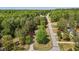 An aerial view showing a home nestled amidst dense trees along a quiet street at 14 Shire Ct, Zebulon, NC 27597