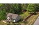 A house with a well-maintained lawn and red fence is surrounded by a forest of lush, mature trees at 14 Shire Ct, Zebulon, NC 27597