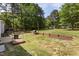 Expansive backyard with lush greenery and a wooden retaining wall at 14 Shire Ct, Zebulon, NC 27597