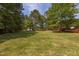 Spacious backyard with lush greenery, trees, and an expansive yard at 14 Shire Ct, Zebulon, NC 27597