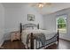 Cozy bedroom with dark hardwood floors, a wrought iron bed frame, and bright natural lighting at 14 Shire Ct, Zebulon, NC 27597