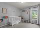 Bright Bedroom with a white crib, neutral decor, and a sunlit window at 14 Shire Ct, Zebulon, NC 27597