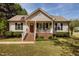Charming single-Gathering home with a cozy front porch, an American flag, and manicured landscaping at 14 Shire Ct, Zebulon, NC 27597
