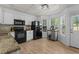 Bright eat-in kitchen featuring white cabinets, black appliances, laminate floors, and natural light at 14 Shire Ct, Zebulon, NC 27597