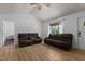 Spacious living room featuring beautiful hardwood floors, natural light, and comfortable brown sofas at 14 Shire Ct, Zebulon, NC 27597