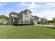 Lush green backyard featuring a basketball court, deck and screened in porch at 1429 Wragby Ln, Apex, NC 27502