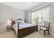 Cozy bedroom features a wooden bed frame, plush bedding, and plenty of natural light at 1429 Wragby Ln, Apex, NC 27502
