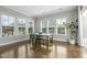 Sunlit dining area featuring large windows, hardwood floors, and a modern table set at 1429 Wragby Ln, Apex, NC 27502