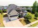 Stunning two-story home with a stone and tan facade, a two-car garage and manicured lawn at 1429 Wragby Ln, Apex, NC 27502
