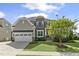 Beautiful home featuring stone accents, a two-car garage, manicured lawn and mature tree at 1429 Wragby Ln, Apex, NC 27502