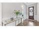 Elegant foyer featuring hardwood floors, a console table, and a view of the front door at 1429 Wragby Ln, Apex, NC 27502