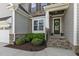 Inviting front entrance with stone accents, a decorative wreath, and lush landscaping at 1429 Wragby Ln, Apex, NC 27502