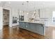 Beautiful kitchen features stainless appliances, gray island with quartz countertops, and wood floors at 1429 Wragby Ln, Apex, NC 27502