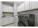 Modern laundry room featuring a washer, dryer, sink, and white cabinets for ample storage at 1429 Wragby Ln, Apex, NC 27502