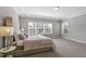 Comfortable main bedroom featuring carpeted floors, a neutral paint color, a tufted headboard, and three windows at 1429 Wragby Ln, Apex, NC 27502