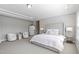 Luxurious main bedroom with tray ceilings, carpeted floors, tufted headboard, and sitting area at 1429 Wragby Ln, Apex, NC 27502