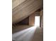 An unfinished attic featuring wooden framing, plywood walls, and a door with natural light at 15 Independence Dr, Smithfield, NC 27577