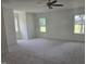 Expansive bonus room with three windows, a ceiling fan, and neutral carpet at 15 Independence Dr, Smithfield, NC 27577