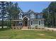 Charming two-story home featuring a covered porch, lush lawn, and a mix of modern and classic design elements at 15 Independence Dr, Smithfield, NC 27577