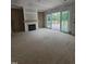 Open living room featuring a fireplace with wood mantle and sliding glass doors to the outdoor deck at 15 Independence Dr, Smithfield, NC 27577