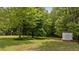 Expansive backyard with mature trees and a shed, creating a serene outdoor setting at 160 Fox Run Rd, Youngsville, NC 27596