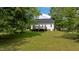 View of a well maintained backyard, deck, and the back of the home with bright green grass at 160 Fox Run Rd, Youngsville, NC 27596